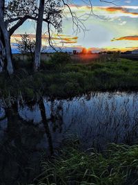Scenic view of lake against sky at sunset