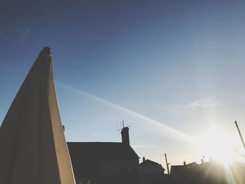 Low angle view of silhouette building against blue sky