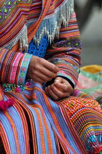 Midsection of woman in traditional clothing sitting outdoors