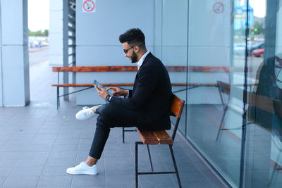 Side view of businessman sitting on bench