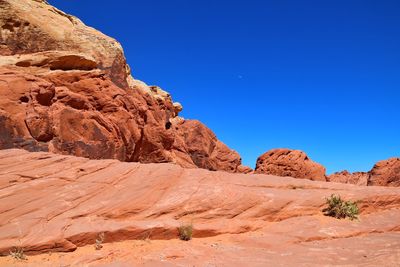 Rock formations on landscape against blue sky