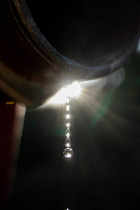 Low angle view of sunlight streaming through illuminated light