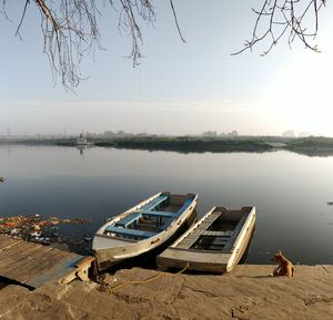 Boats moored on lake against sky