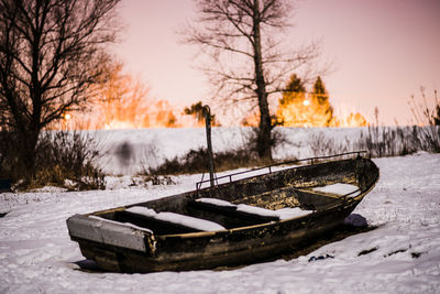 Boat on snow covered field against sky
