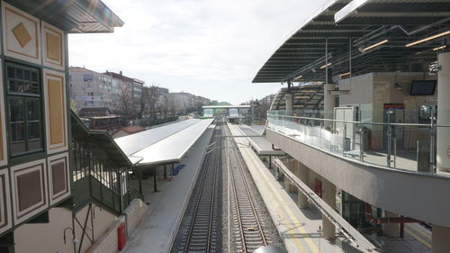 Railroad tracks amidst buildings in city against sky