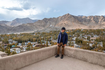 Full length of man standing on mountain against sky