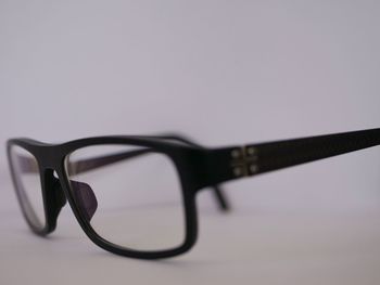 Close-up of eyeglasses on table against white background