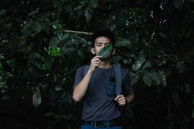 Young man using mobile phone while standing on land