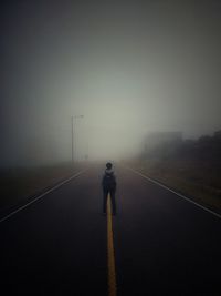 Rear view of man walking on road