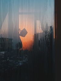 Digital composite image of glass window against sky during sunset