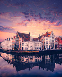 Reflection of buildings in lake during sunset