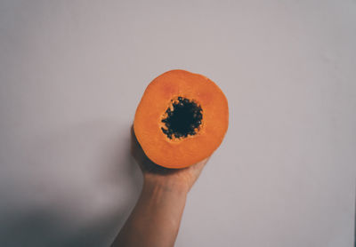 Close-up of hand holding papata against white background