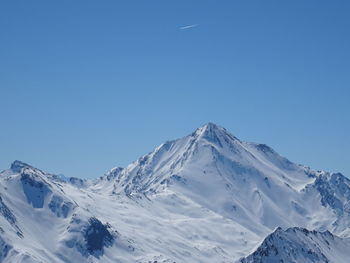 Scenic view of snowcapped mountains against clear blue sky