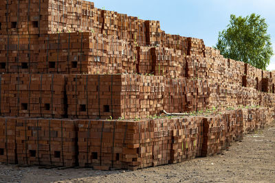 Pallets with red bricks on industrial site.