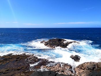 Scenic view of rocky coast against sky