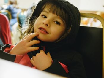 Close-up portrait of cute girl in hood clothing at home