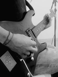 Midsection of man playing guitar