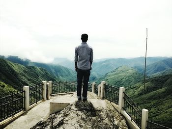 Rear view of man looking at mountains from observation point