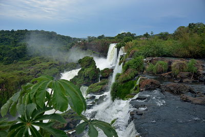 Scenic view of waterfall against sky