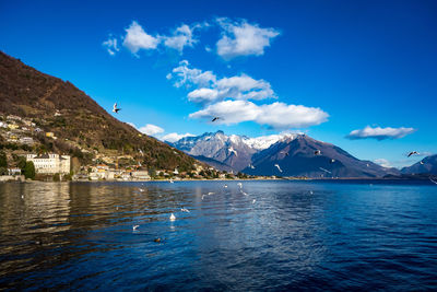 Scenic view of sea and mountains against blue sky