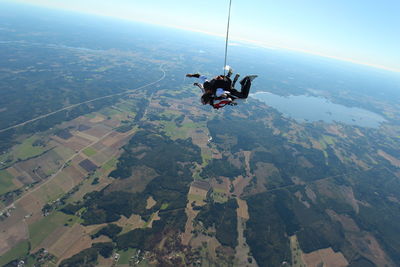 People skydiving over landscape