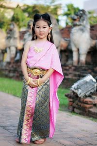 Portrait of smiling woman standing on pink outdoors