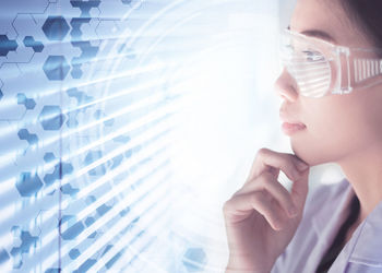 Digital composite image of scientist looking at molecular structure in laboratory