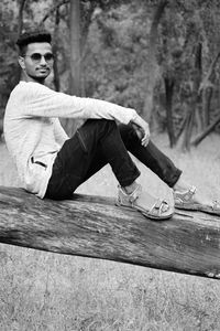 Portrait of young man sitting on wood