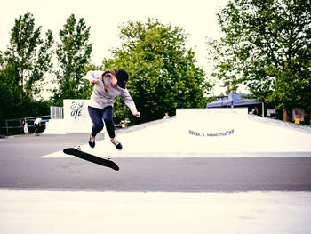 Full length of boy playing with skateboard