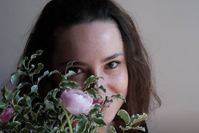 Close-up portrait of woman with pink flower