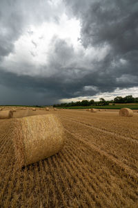 Hay bales on field against sky