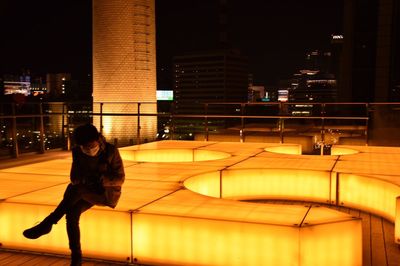 Woman in illuminated city at night