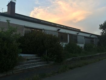 Staircase by building against sky during sunset