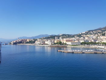 City by sea against clear blue sky