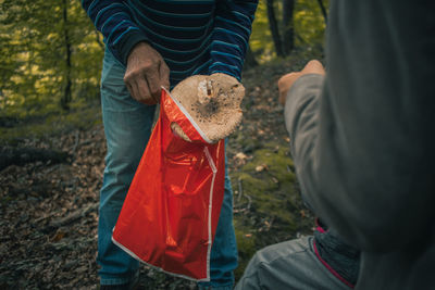 Midsection of man holding umbrella while standing on land