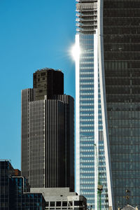 Low angle view of modern buildings against clear blue sky