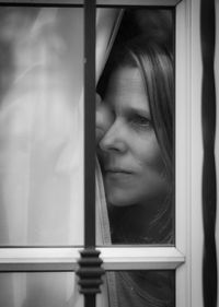 Close-up of young woman against window