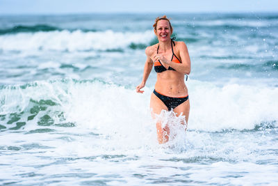 Happy woman wading in sea