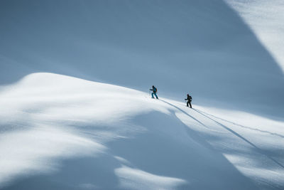 Silhouette of two skiers ski touring in the backcountry of the alps in lienz, austria.