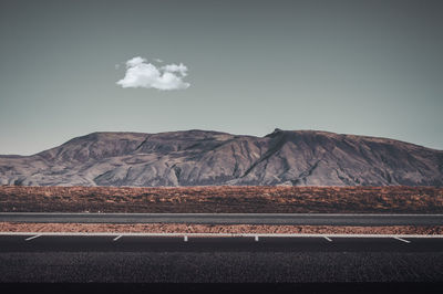 Scenic view of land and mountains against sky