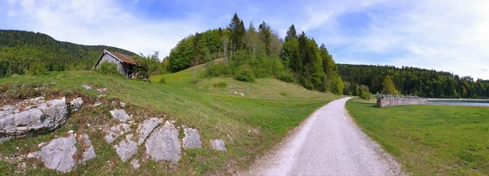 Road amidst green landscape against sky