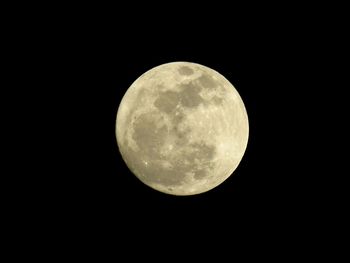 Low angle view of full moon against clear sky at night