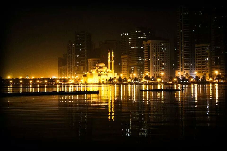 building exterior, city, illuminated, night, skyscraper, architecture, built structure, water, reflection, office building, cityscape, modern, urban skyline, tall - high, river, city life, waterfront, tower, financial district, sky