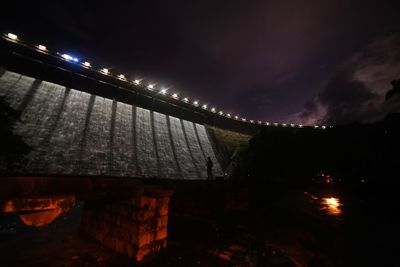 Low angle view of illuminated building against cloudy sky