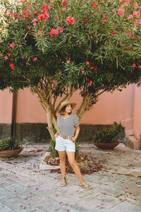 Portrait of young woman standing by tree