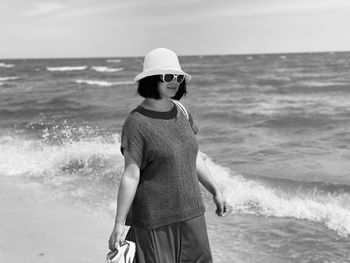 Full length of man standing at beach against sky