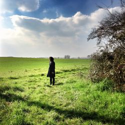 Rear view of man standing on grassy field