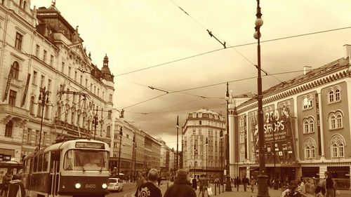 People on street in city against sky