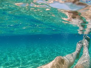 Low section of man swimming in sea