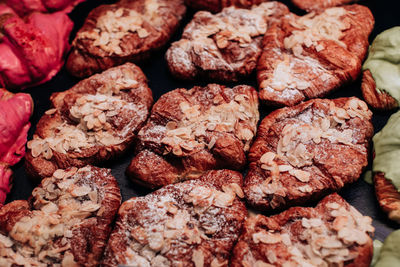 Lots of sweet freshly baked croissants with almonds and powdered sugar. delicious dessert